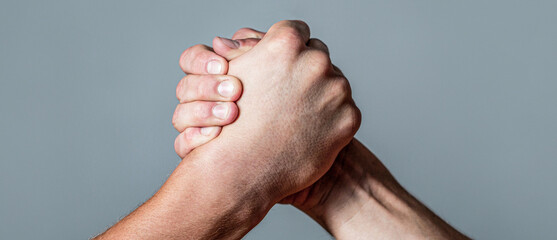 Wall Mural - Arms wrestling. Closep up. Friendly handshake, friends greeting, teamwork, friendship. Handshake, arms, friendship. Man hand. Two men arm wrestling