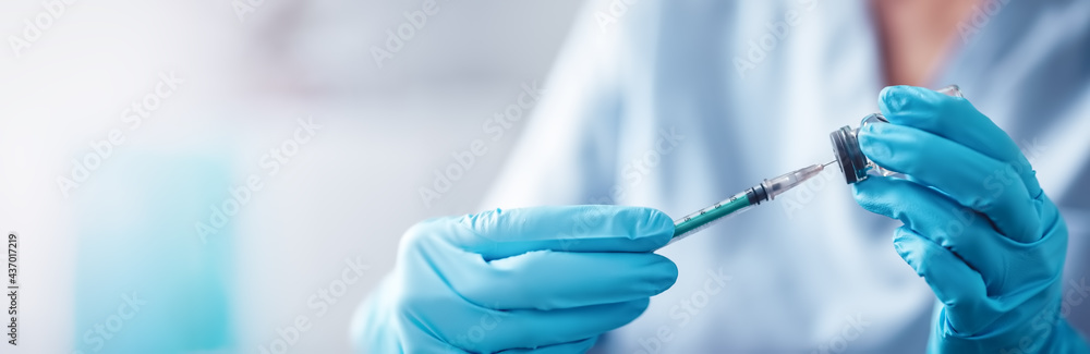 Nurse in surgical gloves holding an injection needle. - obrazy, fototapety, plakaty 