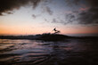 © ADDICTIVE STOCK - Unrecognizable athlete practicing surfing on ocean wave at sunset