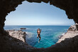 © ADDICTIVE STOCK - Smiling man showing fuck gesture while jumping over sea