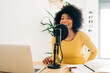 © ADDICTIVE STOCK - Positive young African American woman talking at online radio station
