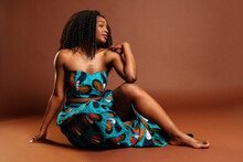 Black Woman Wearing Colorful Dress Sitting On Floor