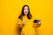 © dianagrytsku - Portrait beautiful young asian woman smile happy use smart mobile phone on yellow background