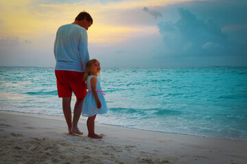 Poster - father and happy little daughter walking on beach at sunset