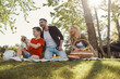 © gstockstudio - Happy young mother and father with little boy smiling while having picnic outdoors
