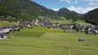 Flug mit der Drohne über Wiesen und Weiden rund um Bezau im Bregenzerwald zur Heuernte im Frühling