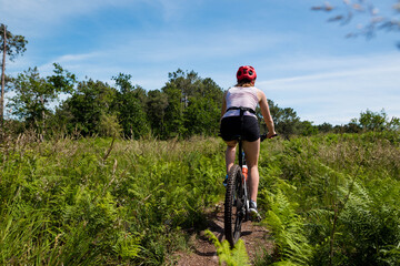 Sticker - pretty young athletic woman mountain biking in nature