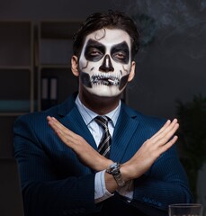 Wall Mural - Businessman with scary face mask working late in office