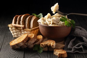 Wall Mural - still life with hot dumplings in a clay bowl and toasted rye bread