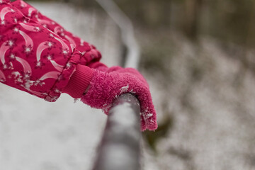 Pink gloves. Winter. Hands holding the handrail. 