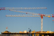 © Gunnar Sommerfeldt - Red and white construction cranes on a building, against a blue sky