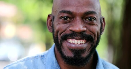 Wall Mural - African man smiling standing outside. Black person portrait face close-up