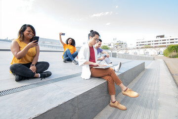 Wall Mural - happy young multi ethnic group with laptop and smart phone in a sunny day