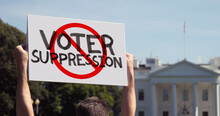 WASHINGTON, DC - Circa March, 2021 - A Man Waves A Handmade STOP VOTER SUPPRESSION Protest Sign Outside The White House.  	