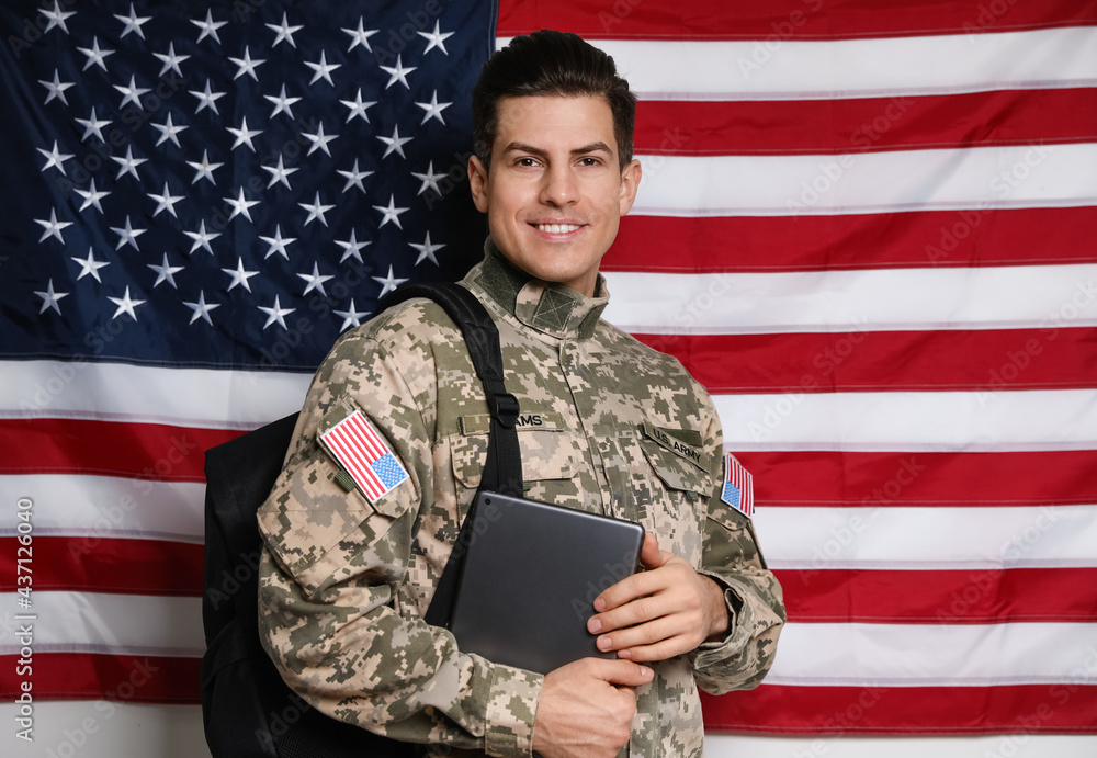 Cadet with backpack and tablet against American flag. Military education - obrazy, fototapety, plakaty 