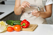 Women's hands hold a garlic press in their hands. Process of cooking something delicious