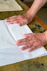 Wall Mural - a calligrapher is folding rice paper and writing calligraphy preparations