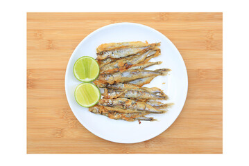 Canvas Print - Grilled shishamo fish served with lemon and sweet sauce on wooden board background. Top view Japanese food