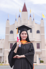 Wall Mural - Female graduates happily celebrate university graduation with diploma