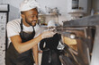 © prostooleh - African merican man baking pizza at commercial kitchen