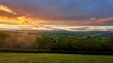 Sunset To Dusk Timelapse Overlooking The Rolling Hills Of The Countryside In Devon From Stoke Hill Near Exeter. UK