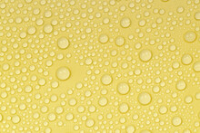 Water Drops On Yellow Background Texture. Backdrop Glass Covered With Drops Of Water. Yellow Bubbles In Water. Beer Texture