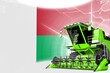 Agriculture innovation concept, green advanced rural combine harvester on Madagascar flag - digital industrial 3D illustration