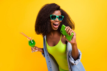 Sticker - Photo portrait of woman drinking cocktail in singing playful in cellphone isolated vivid yellow color background