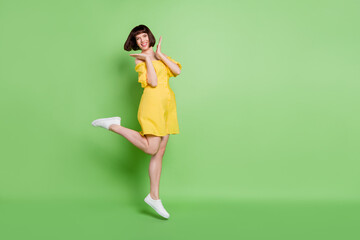 Sticker - Full length body size view of attractive cheerful lucky girl having fun jumping isolated over green color background