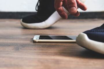 Wall Mural - the cell phone fell to the ground and the man bent over for it