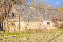 Old Barn Near Trees At Spring On A Sunny Day. Old Farm
