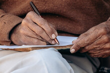 Old Man Writing Notes In Notebook. Close Up. Senior Man Signing Agreement	