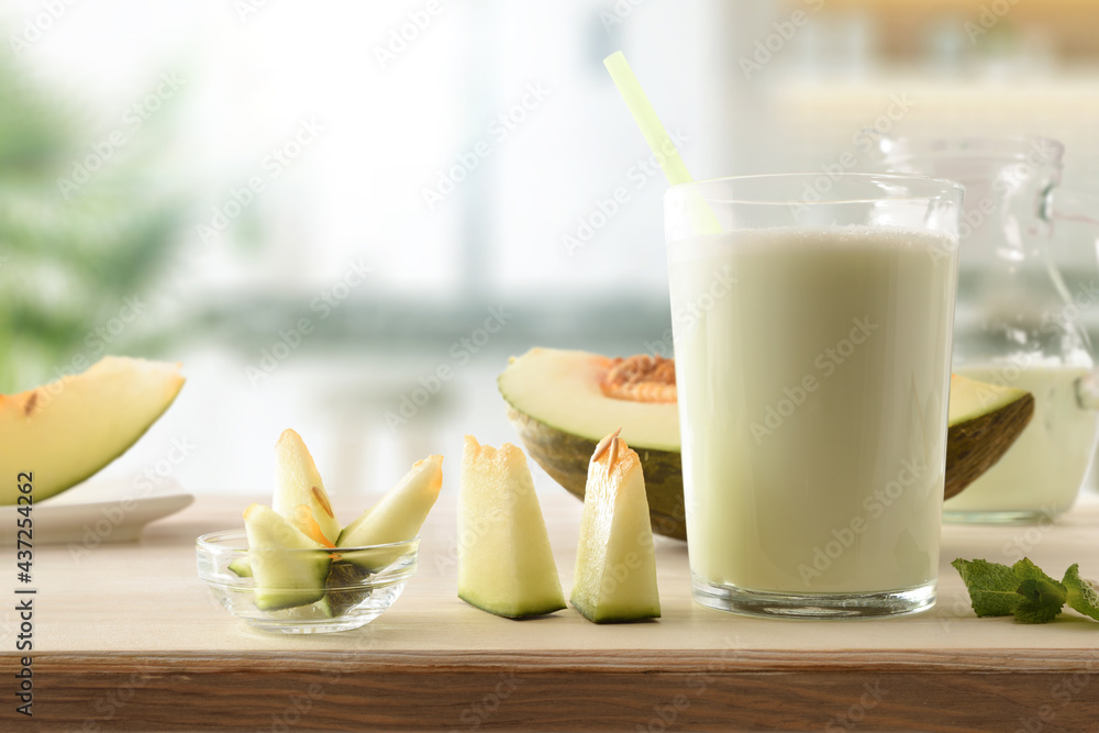 Glass with melon milk shake on bench in kitchen front - obrazy, fototapety, plakaty 
