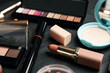 Different makeup products on black slate table