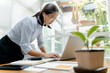 © mojo_cp - Young asian woman secretary working with laptop at contemporary office..