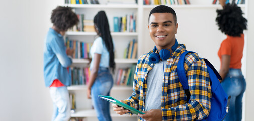 Wall Mural - Laughing hispanic male student with braces and group of american students