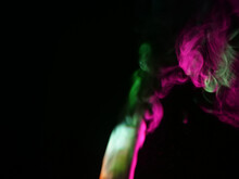 Abstract Colour Series. Composition Of Colourful Smoke In Motion. Fusion Of Green And Purple Mist Isolated On A Dark Background To Inspire Creativity.