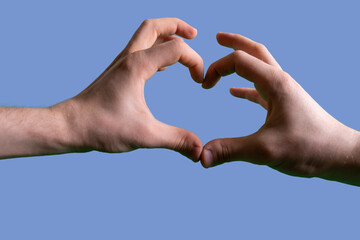 hands fingers make a symbol of the heart shape against the sky