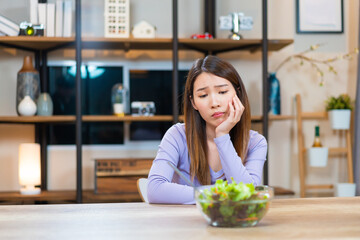 Asian woman bored to eat vegetable salad want to quit vegetarian