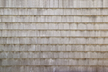 Dry aged weathered cedar shingle siding texture on an old summer cottage home building