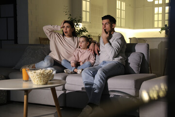 Poster - Family watching movie with popcorn on sofa at night