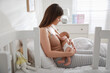 Young mother breastfeeding her newborn baby at home