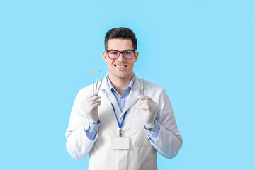 Wall Mural - Male dentist with tools on color background