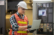 © nikomsolftwaer - Engineer control and check robot working in factory. The worker is controlling the robot to work in the factory. Portrait of female factory worker.  Engineer women are working with machines cnc