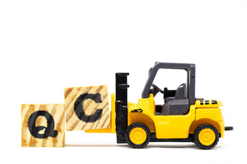 Canvas Print - Toy forklift hold letter block c to complete word QC (Abbreviation of Quality Control) on wood background