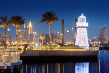 Wall Mural - Illuminated decorative lighthouse near the parking lot of yachts and ships in the Dubai Creek Marina Harbor. Travel and tourist destinations