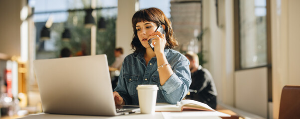 businesswoman talking on cell phone in coworking space