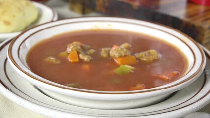 Poster - Ladling steaming hot homemade meatball soup into a bowl
