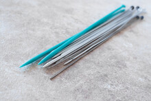 Heap Of Knitting Needles On The Table Top View. Knitting Blurred Background.