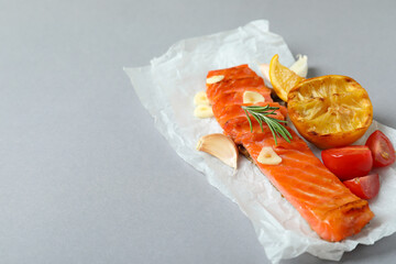 Concept of tasty eating with grilled salmon on gray background